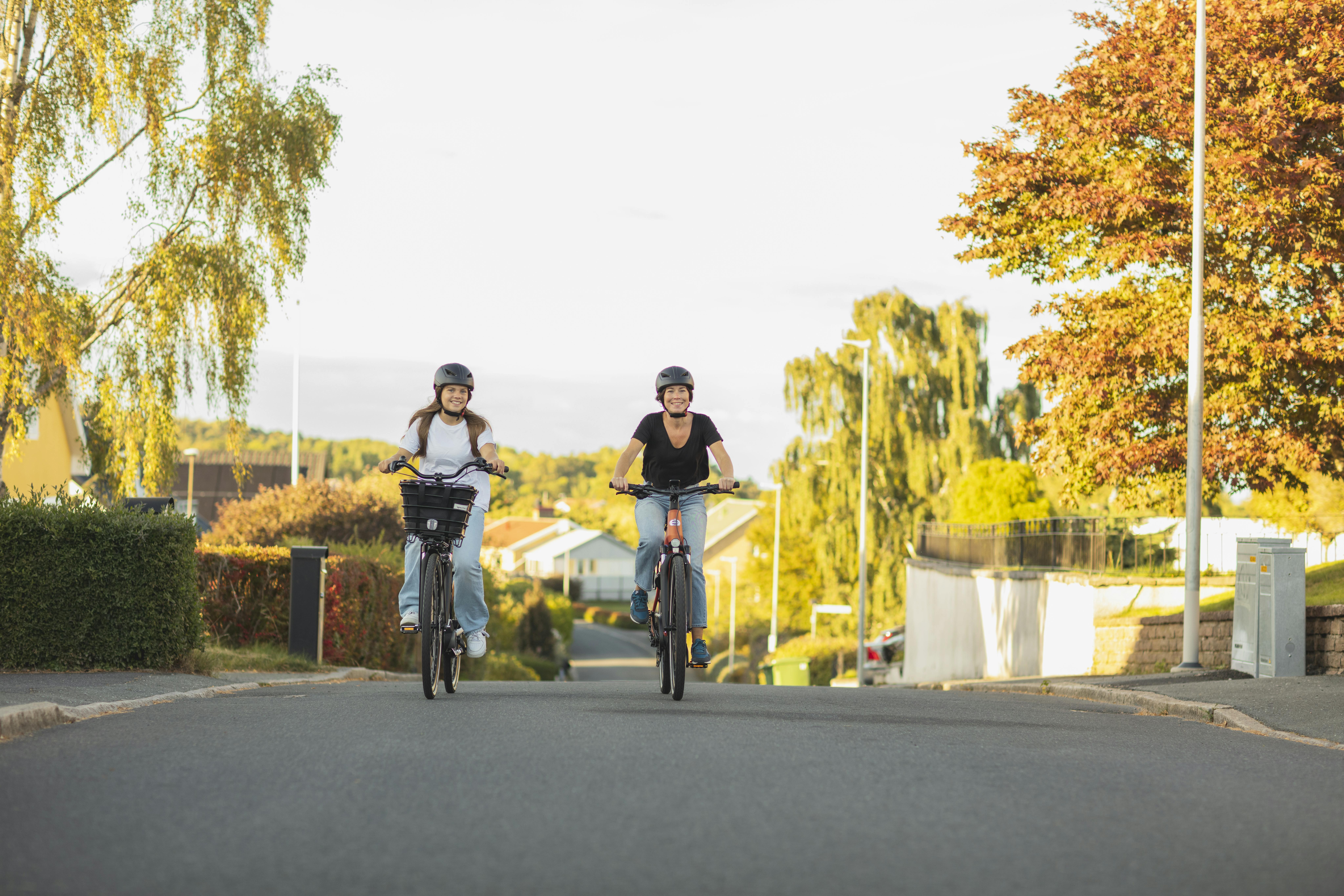 Kvinna och flicka cyklar i ett villaområde (Crescent)